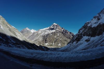 Scenic view of snowcapped mountains against clear blue sky