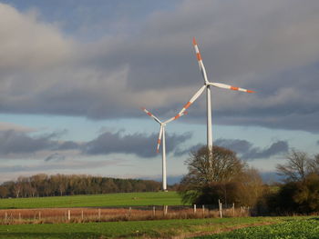 Windmill on field against sky