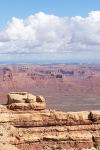 Rock formations on landscape against cloudy sky