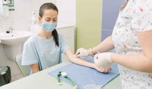 Midsection of doctor vaccinating patient