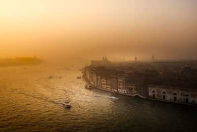 High angle view of ship sailing in sea during sunset