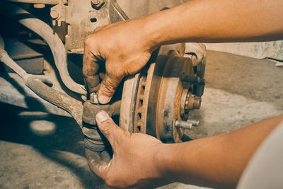 Close-up of man working on bicycle