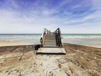 Lifeguard hut on beach against sky