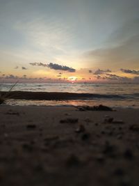 Surface level of sea against sky during sunset