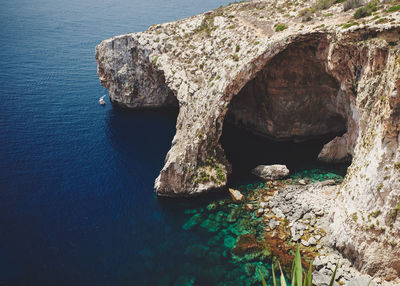 High angle view of rocks in sea at the blue grotto on malta