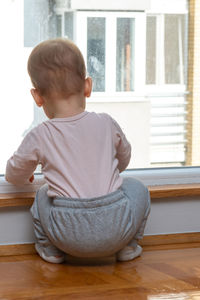 Side view of boy sitting on table