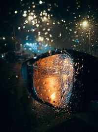Close-up of raindrops on illuminated glass
