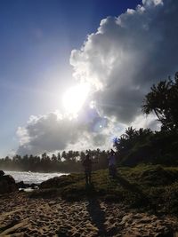 People standing on shore against sky