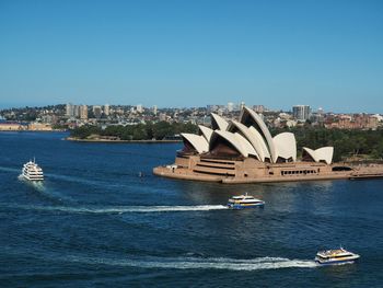 Boat in city against clear blue sky