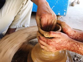 Cropped image of friends molding pot at workshop