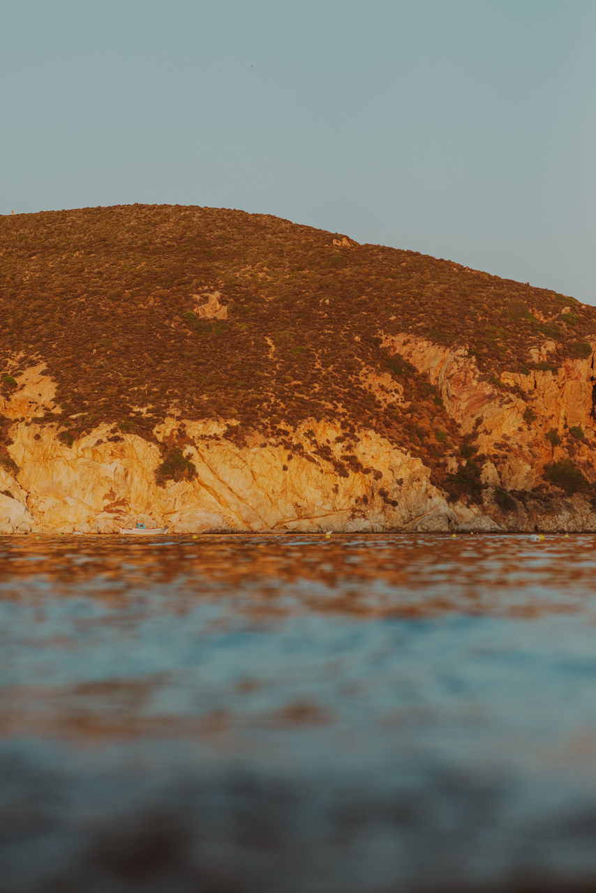 sea, rock, sand, water, reflection, coast, sky, nature, natural environment, no people, shore, land, environment, landscape, horizon, ocean, beauty in nature, morning, scenics - nature, tranquility, wave, day, beach, outdoors, geology, tranquil scene, clear sky, mountain, desert, wood, non-urban scene, terrain, soil
