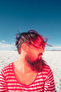 Mid adult man at beach against sky