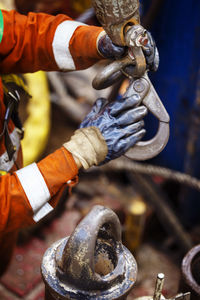 Cropped image of manual worker holding metallic hook