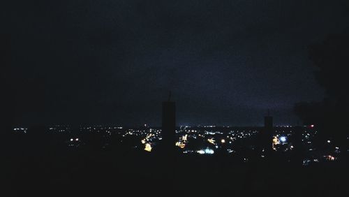 Low angle view of illuminated cityscape against sky at night