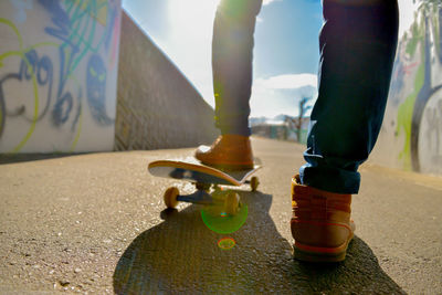 Low section of man standing on skateboard