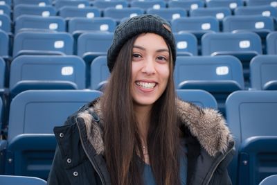 Portrait of smiling young woman on blue seat