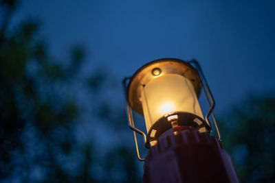 Low angle view of illuminated electric lamp against blue sky