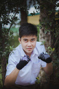 Portrait of young man practicing boxing in park