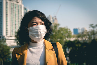 Close-up of woman wearing mask standing outdoors