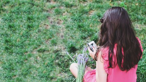 Midsection of woman standing by plants on field