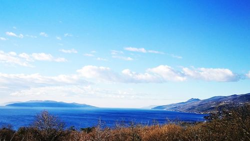 Scenic view of mountains against blue sky