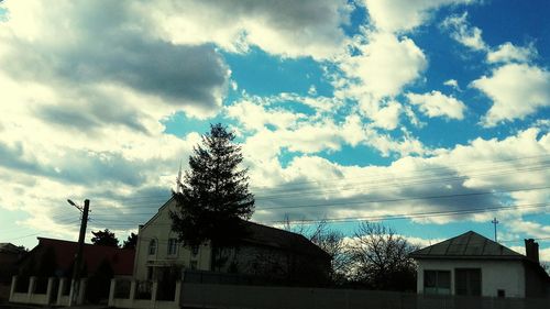 Low angle view of houses against cloudy sky