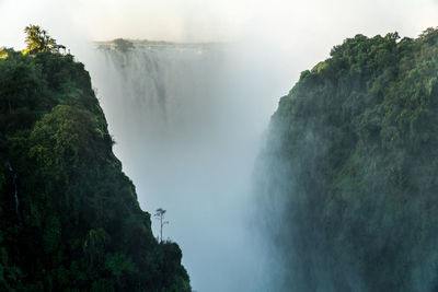 Scenic view of waterfall in mountains