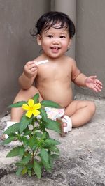 Full length of shirtless baby girl against wall