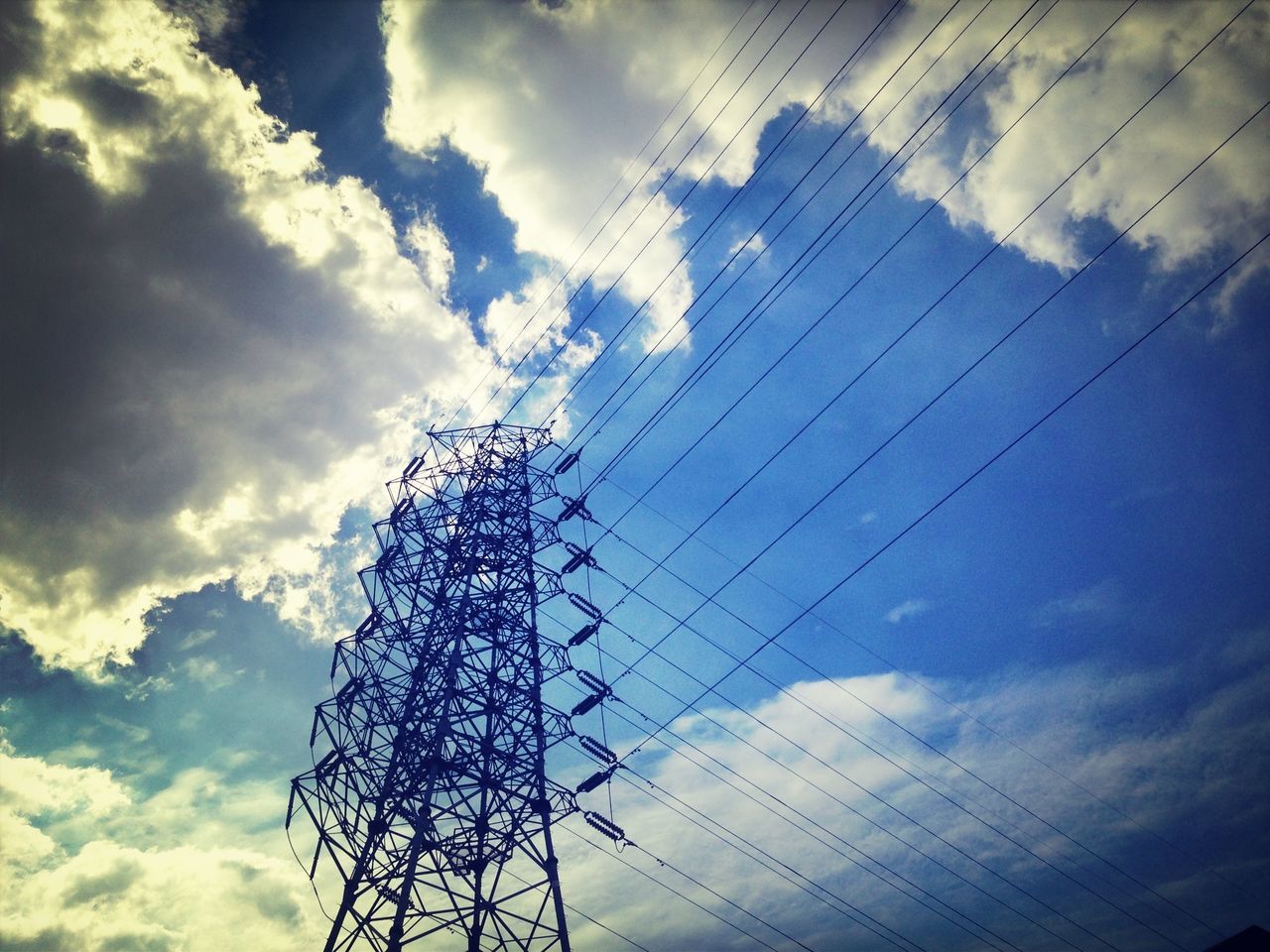 low angle view, sky, cloud - sky, cloudy, silhouette, cloud, built structure, power line, tall - high, architecture, electricity pylon, electricity, building exterior, blue, outdoors, technology, day, no people, cable, connection