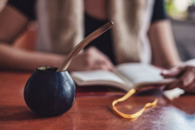 Close-up of hand holding book on table