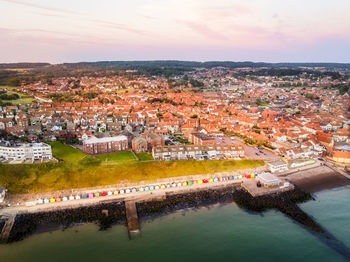 High angle view of townscape by sea against sky during sunset