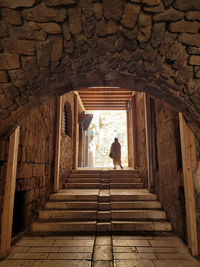 Rear view of woman standing by staircase in building