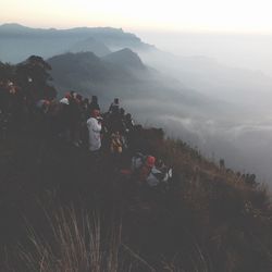 People on mountain against sky