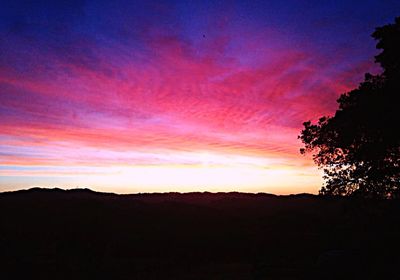 Scenic view of dramatic sky over silhouette landscape