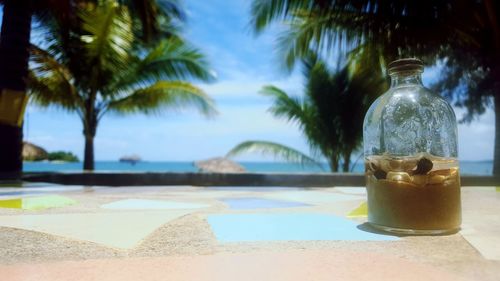 Close-up of bottle on table at beach
