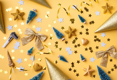 Top view of golden christmas and new year decorations with confetti and gift boxes flat lay