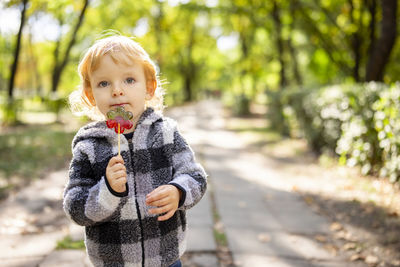 Portrait of cute girl looking away while standing outdoors