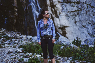 Full length of young woman standing on rock