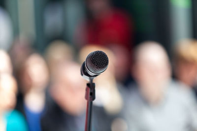 Close-up of microphone against crowd