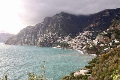 Scenic view of sea and mountains against sky