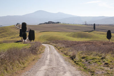 Road amidst field against sky