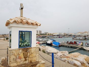 Built structure by sea against sky