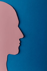 Close-up of human face against blue background