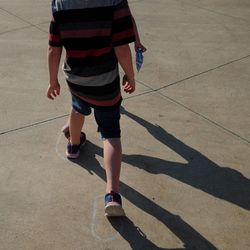 Low section of boys playing on footpath