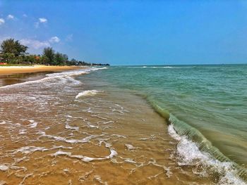 Scenic view of beach against blue sky