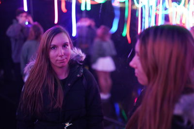 Portrait of woman with female friend in nightclub