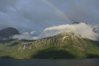 Scenic view of rainbow over mountains against sky