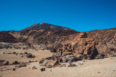 Scenic view of rocky mountains against clear blue sky