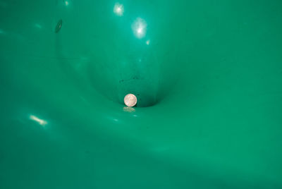 Eine weiße kugel rollt in einem grünen behälter ins loch