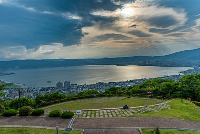 High angle view of city by sea against sky